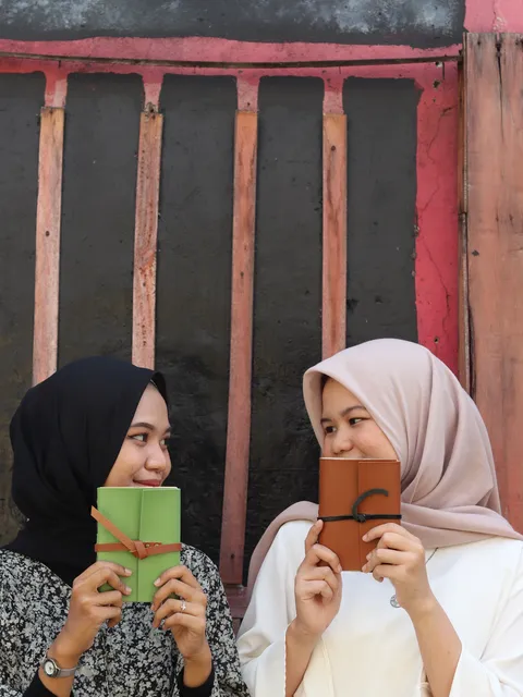 Dua Gadis Saling Berpandangan Memegang Jurnal Hibrkraft