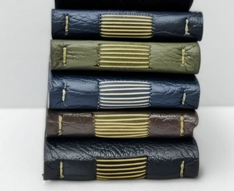 Tumpukan jurnal kulit dengan jahitan longstitch yang terlihat di punggung
