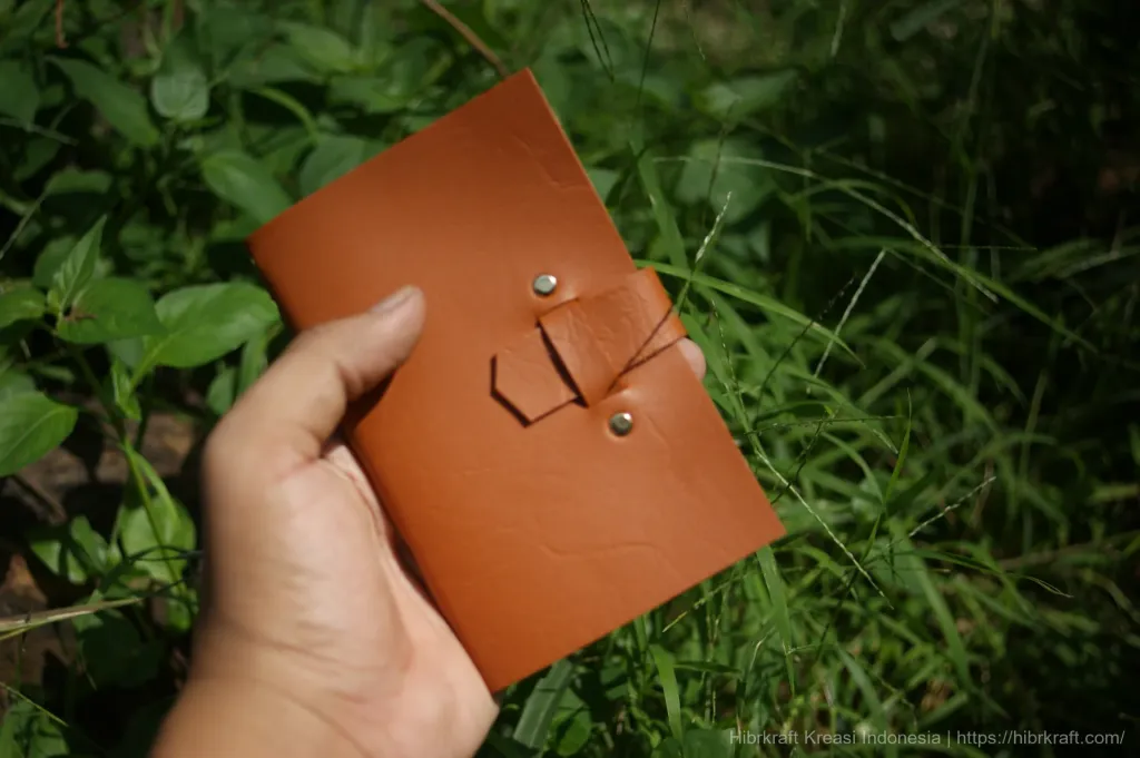 10100522 Hibrkraft Hand Holding Brown Leather Notebook