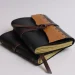 Two Black And Tan Leather Notebooks Stacked