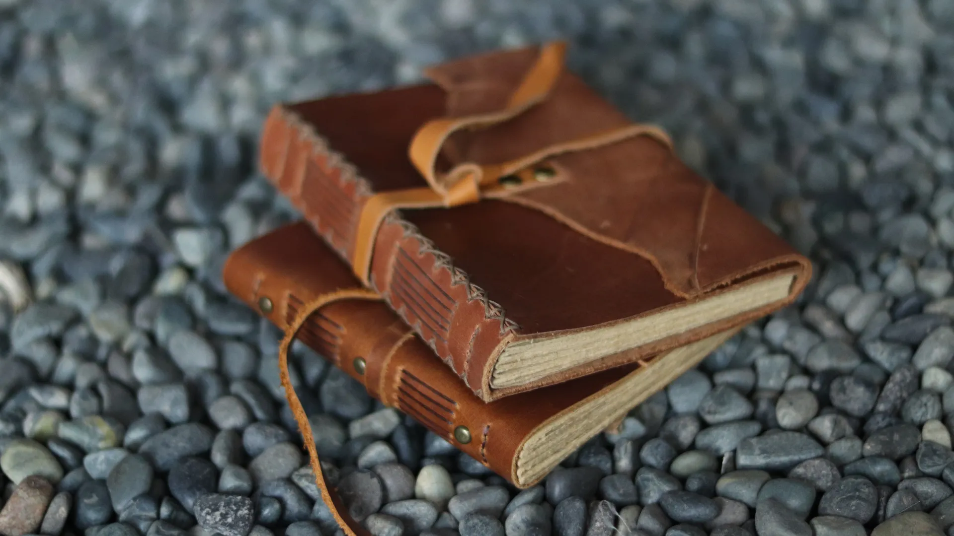 Two Brown Leather Journals On Pebbles