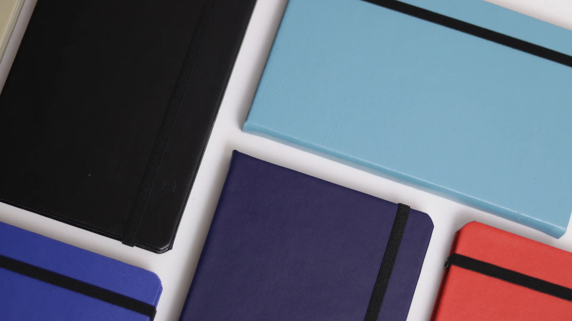 Variety Of Colored Leather Notebooks With Black Elastic Bands