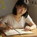 Woman Writing In Planner At Desk Sunlight