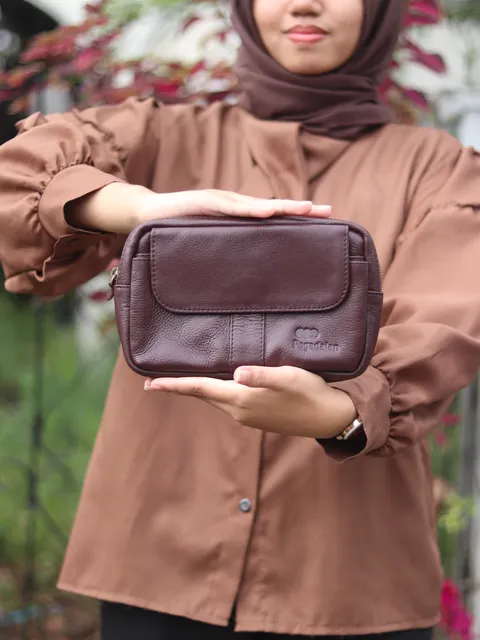 Dompet clutch kulit coklat yang dipersonalisasi, menunjukkan detail kerajinan tangan