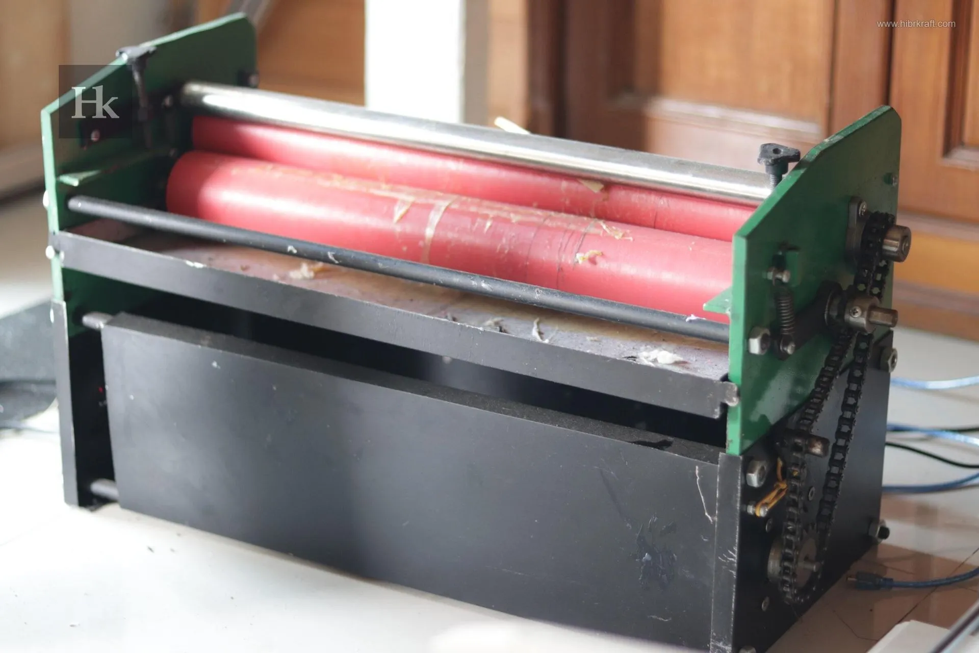 Mesin pemotong hidrolik besar berwarna krem dengan desain industrial, siap untuk memotong tumpukan kertas dengan presisi tinggi.