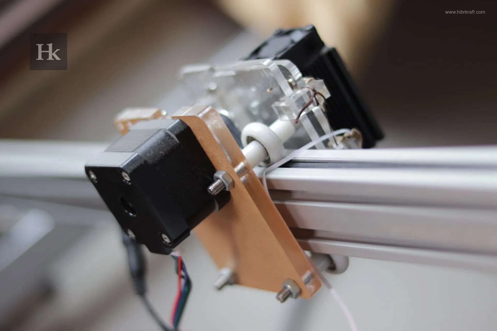 Close-up motor stepper yang dipasang pada rangka aluminium, bagian penting dari sistem gerakan presisi untuk mesin laser atau CNC.