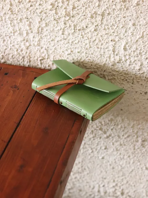 Buku catatan kulit berwarna mint green, contoh produk custom notebook yang bisa dihasilkan.