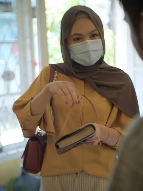 Wanita dengan notebook kulit premium, menunjukkan keindahan dan kualitas produk Hibrkraft yang dibuat dengan teliti.