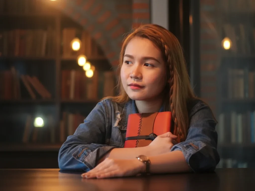 Young Woman Holding Book In Library