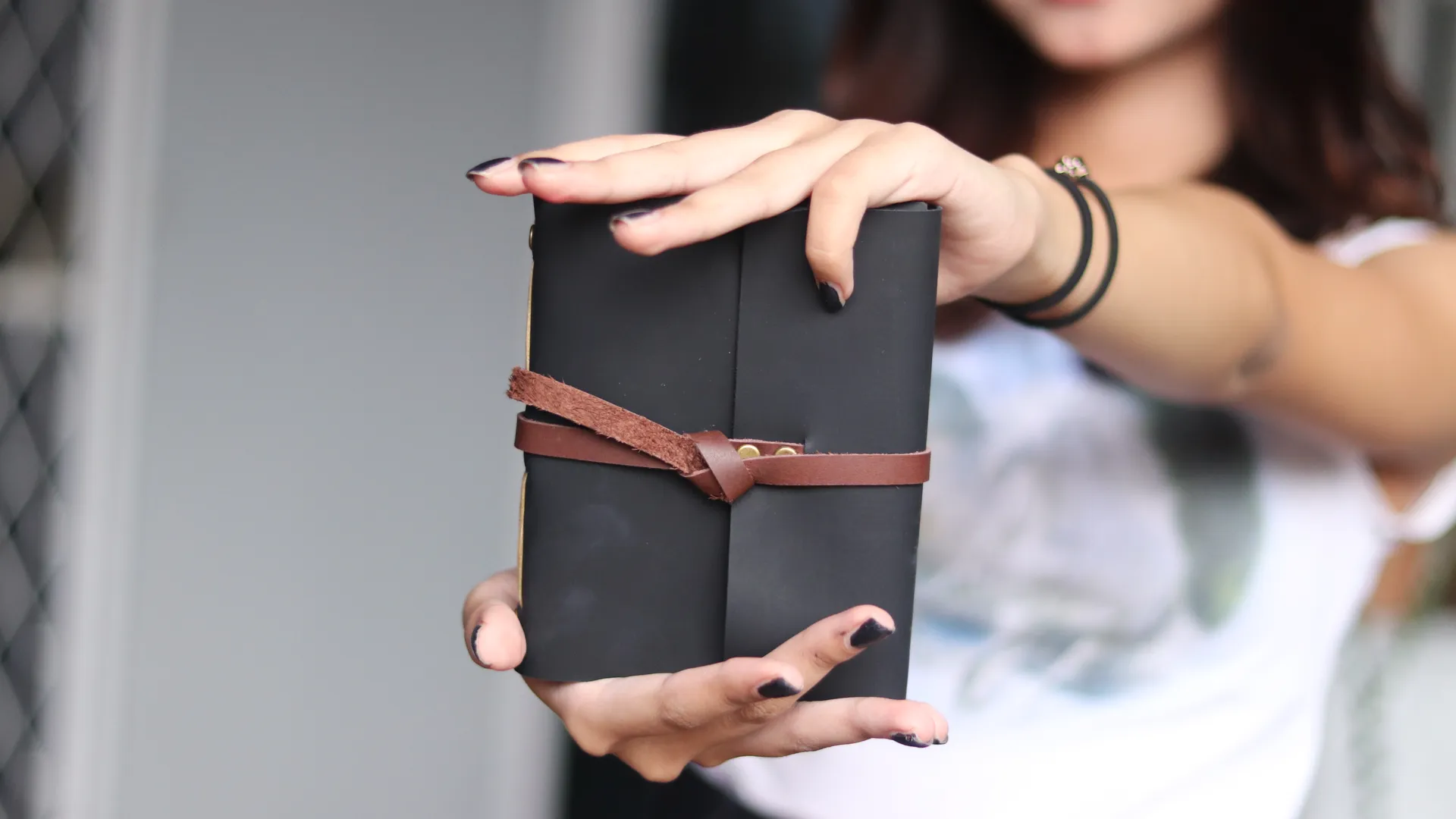 Detail close-up dari tekstur jurnal kulit hitam, menunjukkan kualitas pengerjaan tangan yang premium.