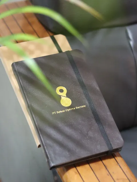 Tampilan dekat custom notebook dengan logo brand yang elegan