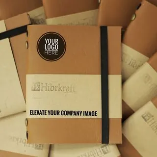 Notebook kulit cokelat custom bertumpuk, salah satunya menampilkan mockup logo perusahaan dan teks “Elevate Your Company Image”