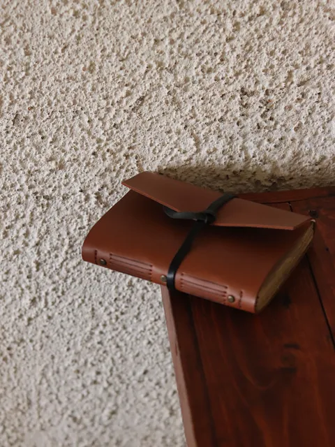 Sebuah custom notebook kulit berwarna coklat tergeletak terbuka, menunjukkan kehangatan dan nilai personal.
