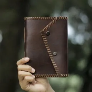 Brown leather notebook in hand - artisan custom personalized journal Brown leather notebook in hand - artisan custom personalized journal