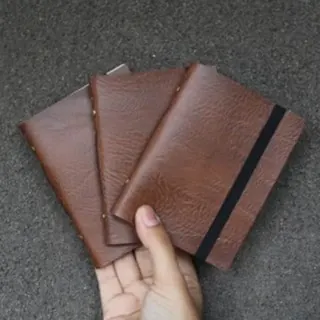 Brown leather notebooks held in hand - premium custom journal Brown leather notebooks held in hand - premium custom journal