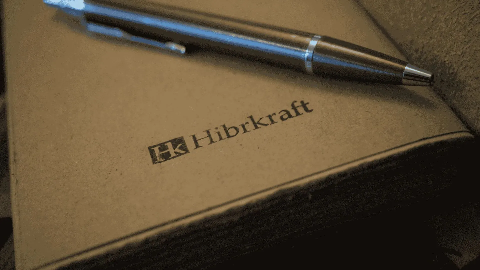 Buku catatan dengan logo Hibrkraft diemboss pada sampulnya
