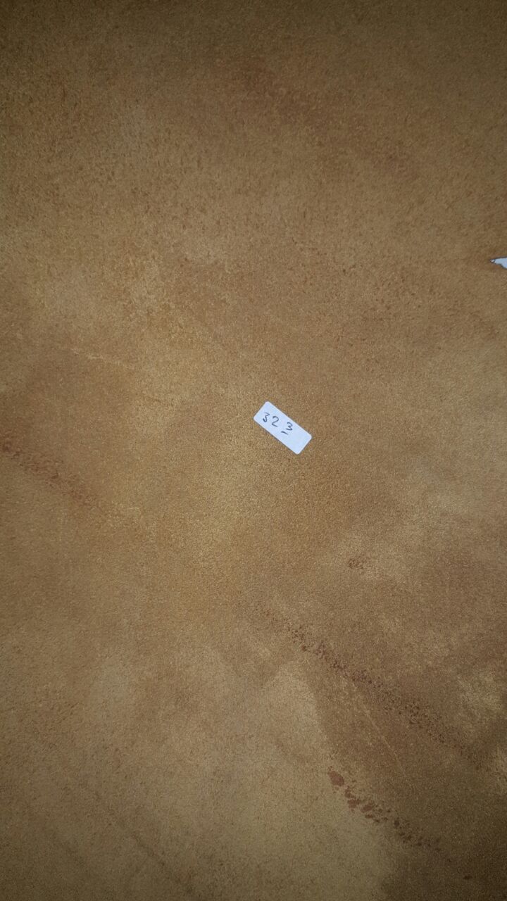 A close up view of the suede underside of a tan leather hide with a small white paper tag