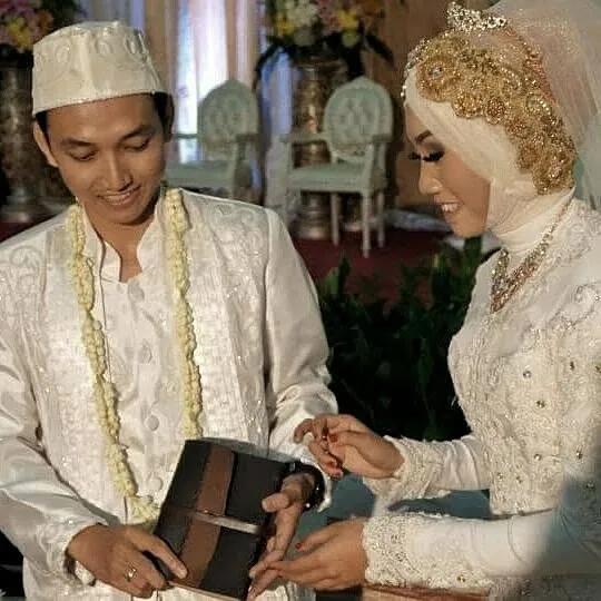A bride and groom holding a Hibrkraft leather journal given as part of the marriage gift
