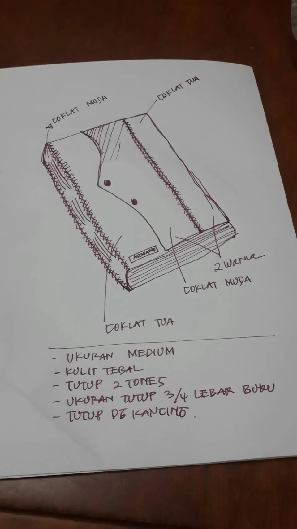 A handwritten design sheet: a drawing of a leather book annotated with two brown colours, medium size, thick leather, and a studded flap