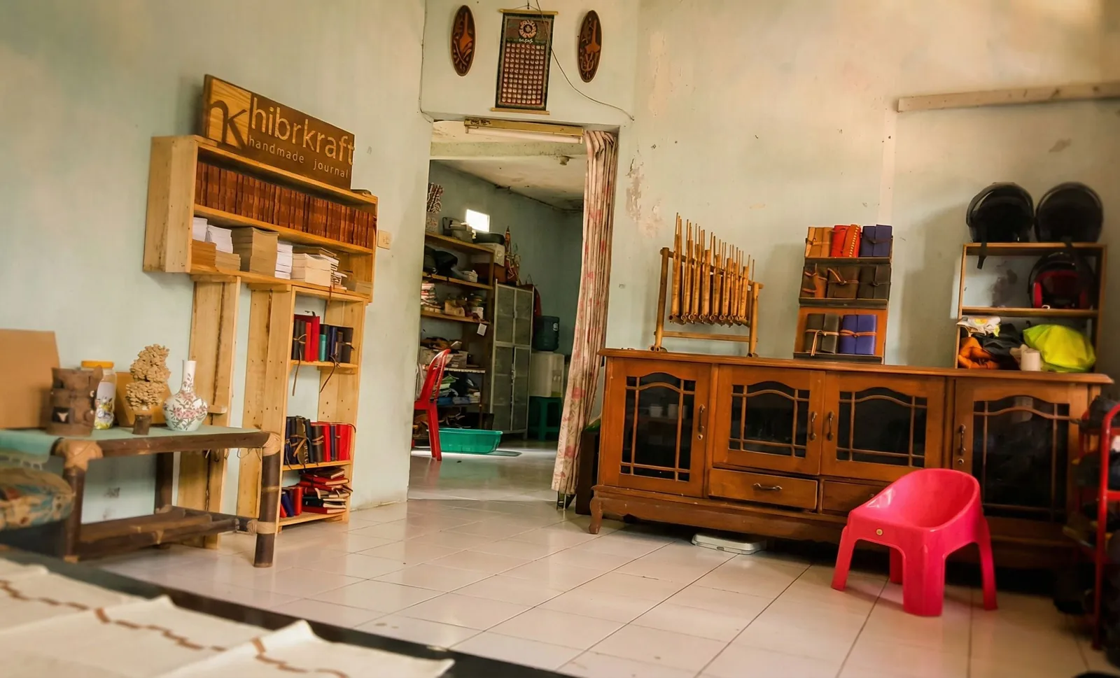 The front room of the Hibrkraft workshop, with its wooden sign and a shelf of leather journals