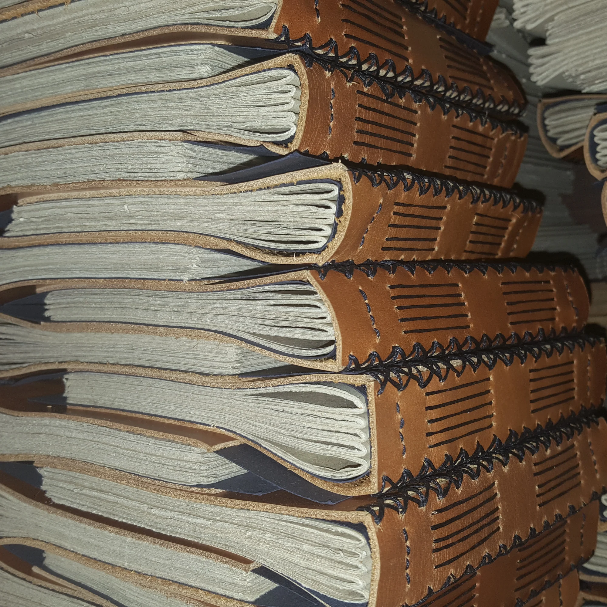A stack of leather journals with coptic binding for the PPLI project.