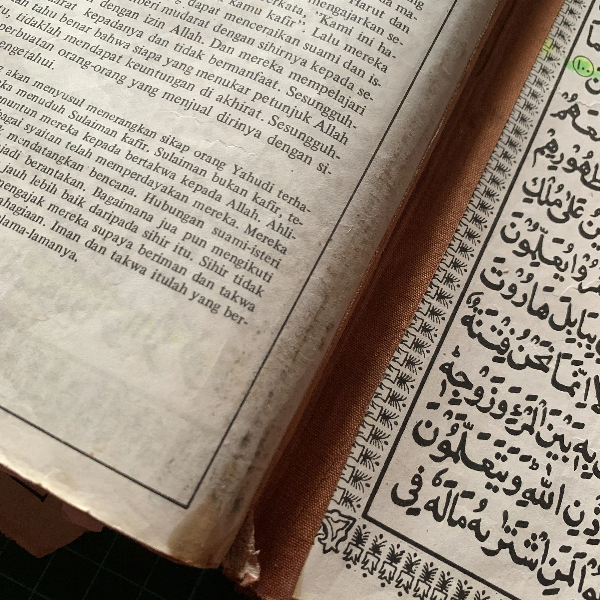 The process of repairing a Quran book with a damaged binding.