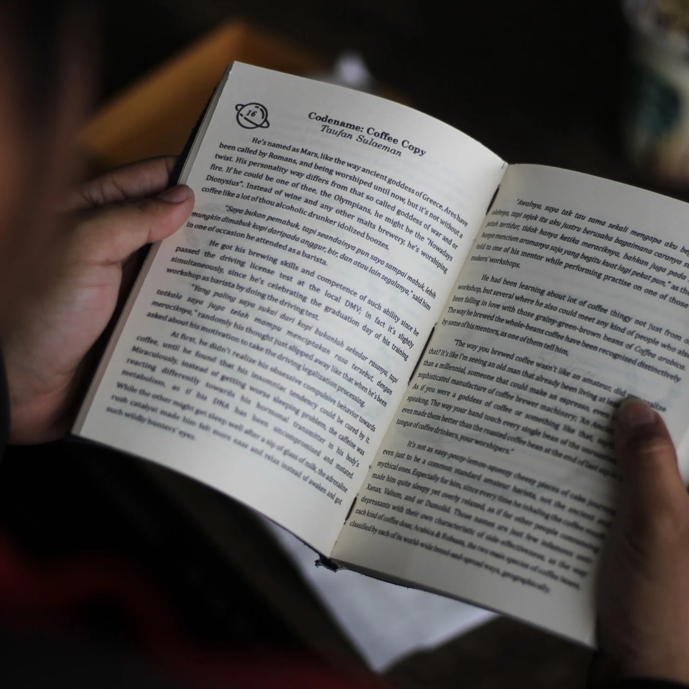 Seseorang memegang dan membaca buku bersampul kulit