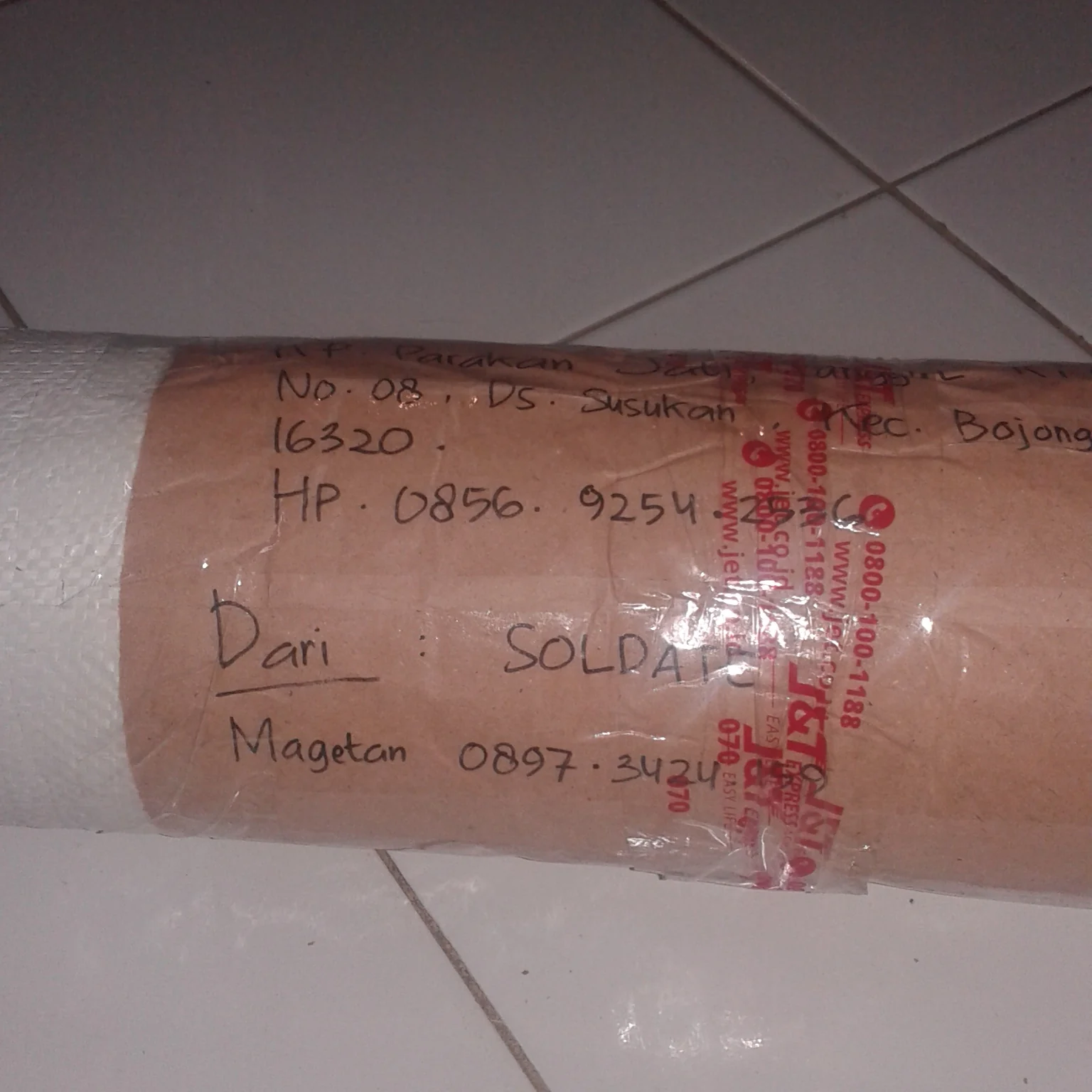 Gulungan kulit terbungkus kertas cokelat dengan label pengiriman