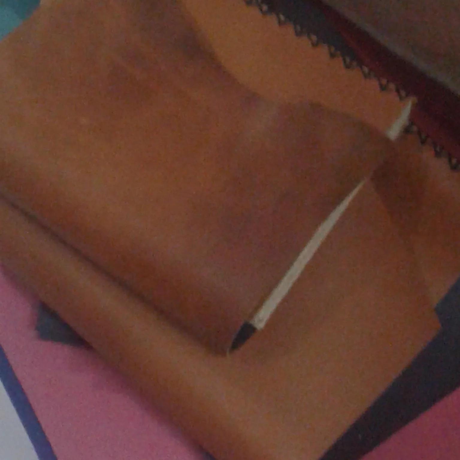 A stack of brown leather journals featuring visible hand stitching.