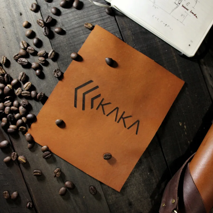 A sheet of leather with a debossed logo, surrounded by coffee beans