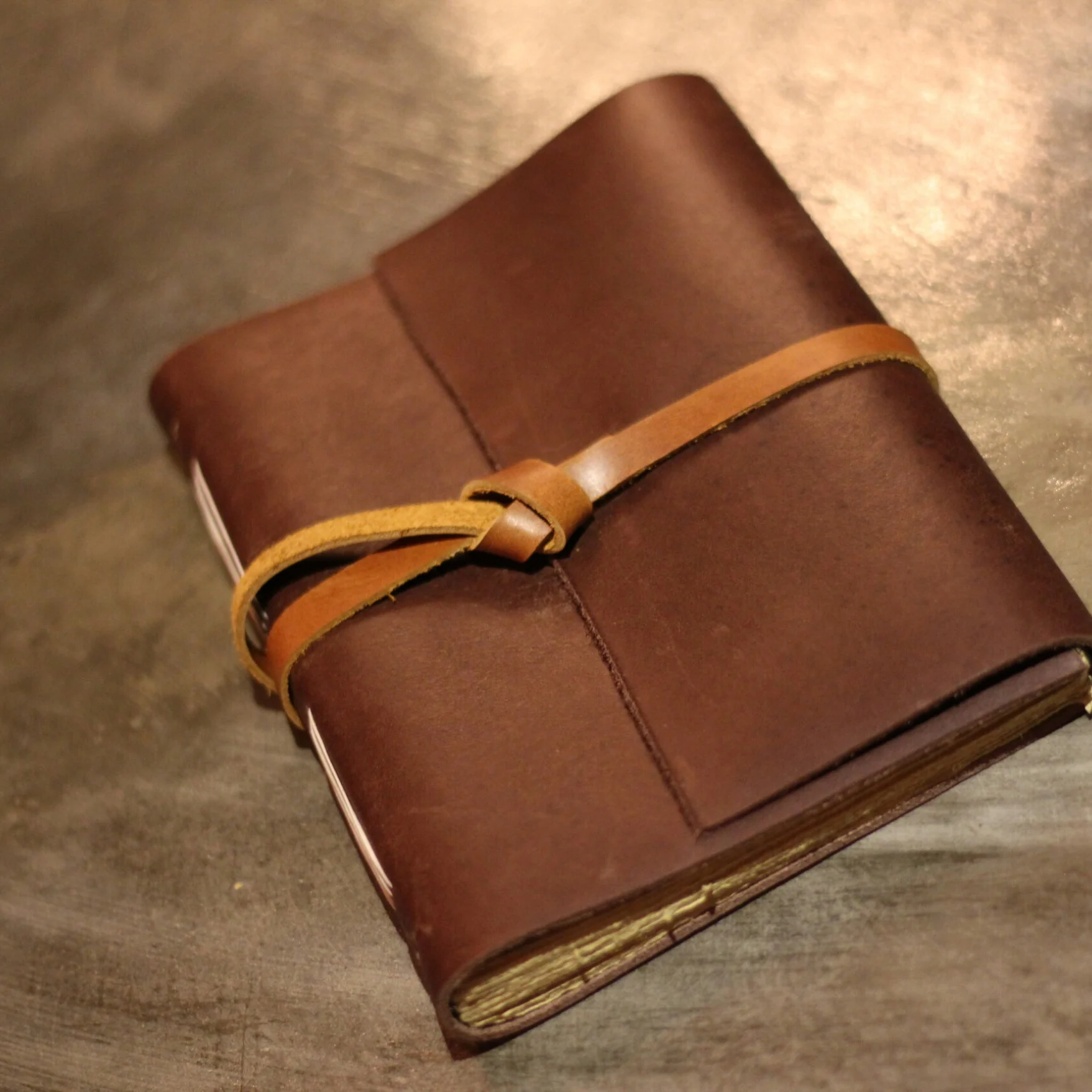 A brown leather journal with a leather tie closure.