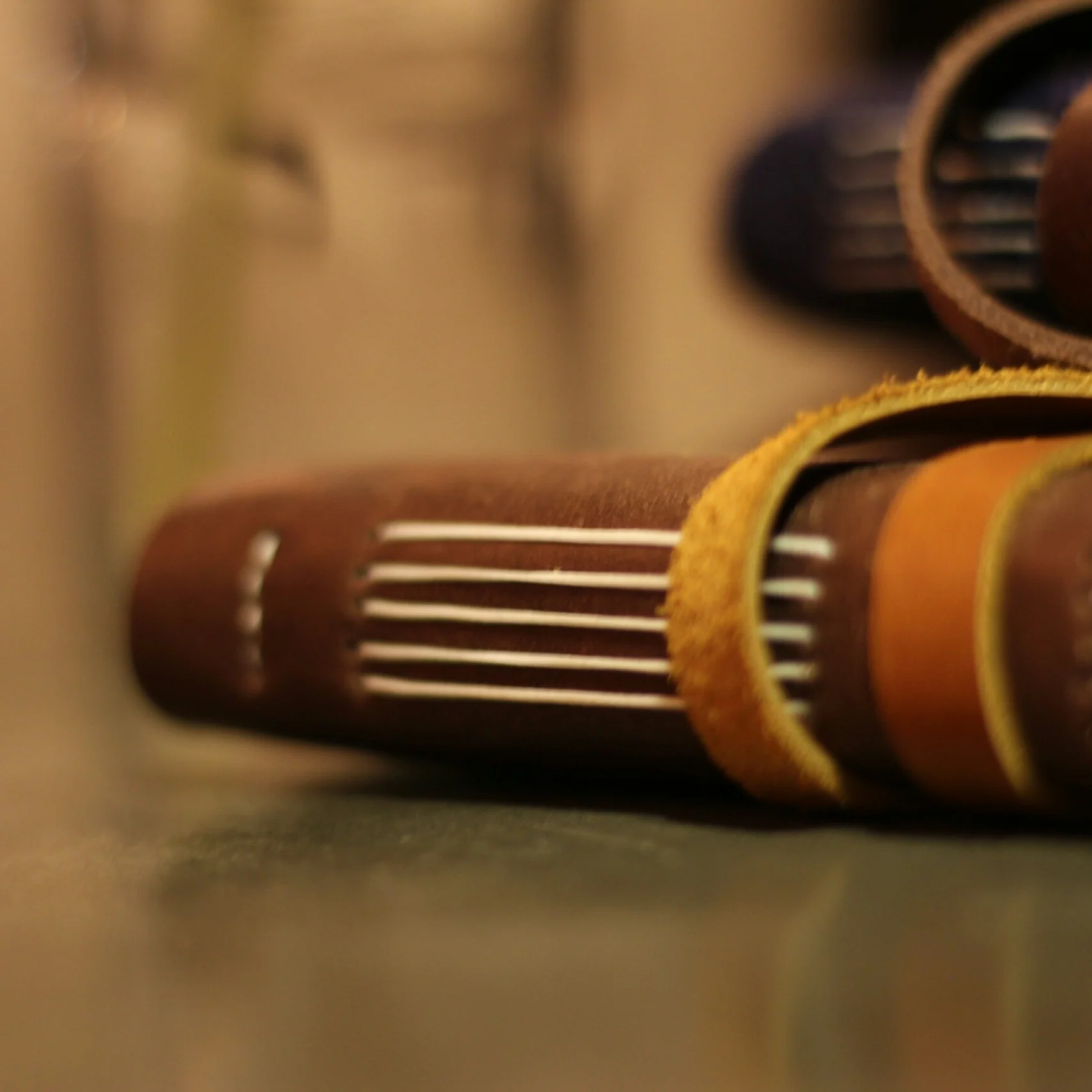 A stack of leather journals with visible coptic stitching.