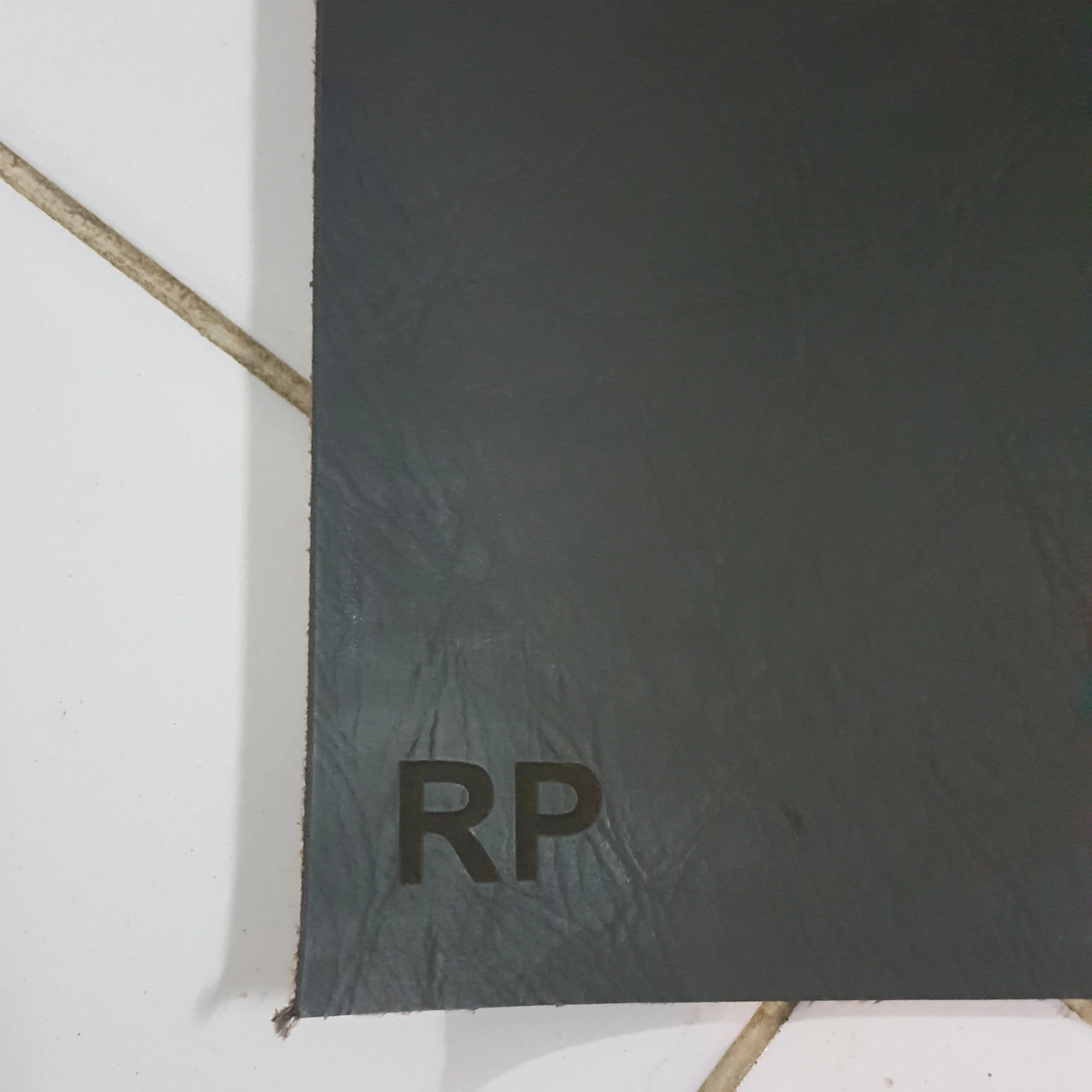 A dark leather sheet with the initials RP embossed