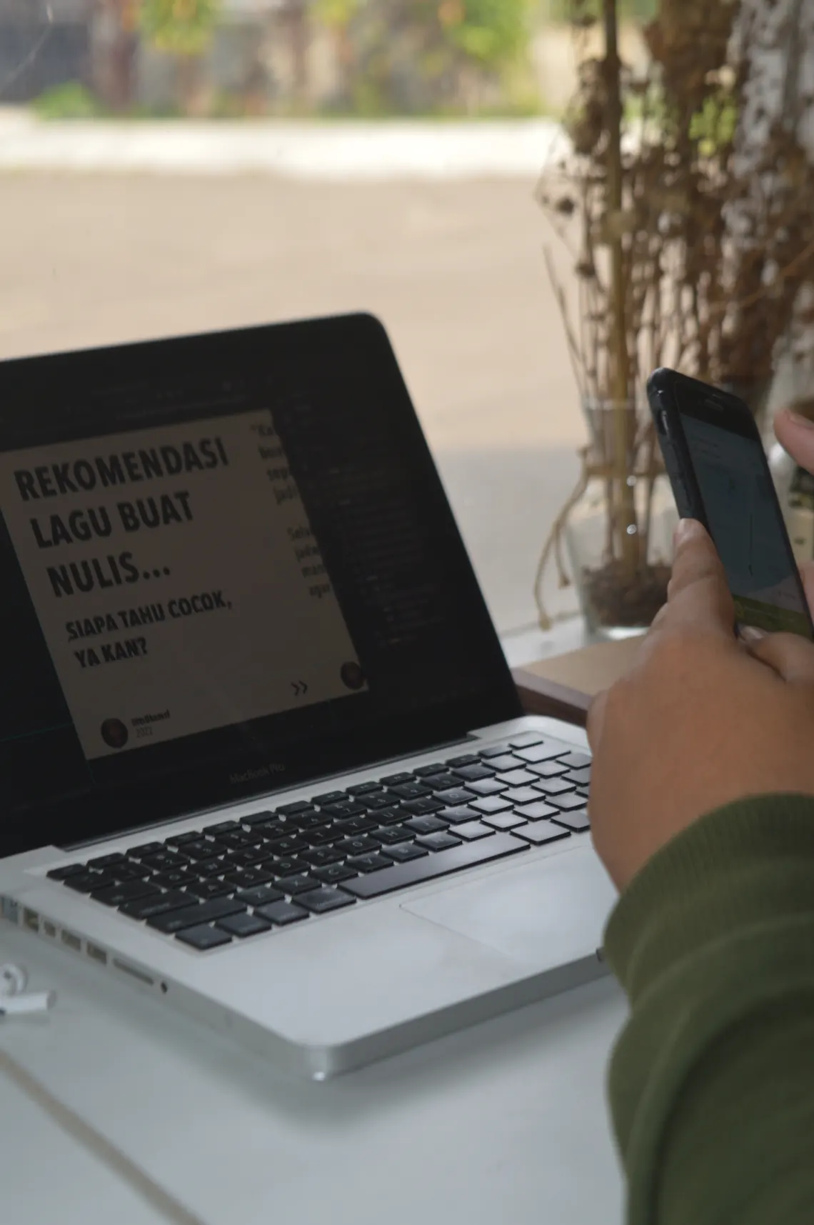 Laptop dan smartphone menampilkan konten digital berdampingan