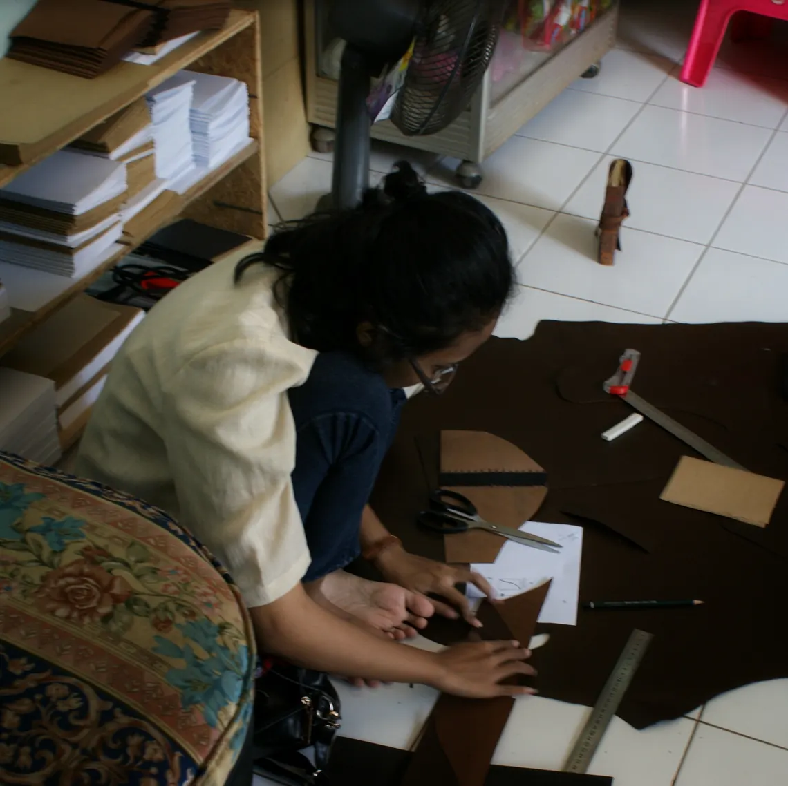 Pengrajin memotong kulit di lantai bengkel saat acara open house