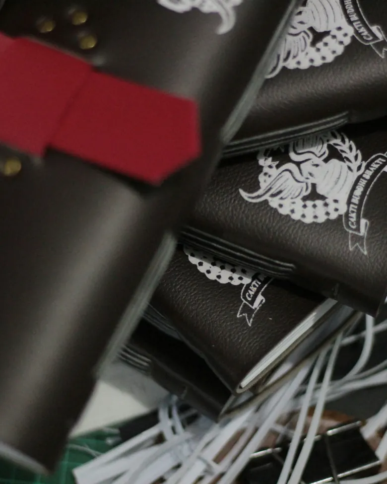 Stack of leather journals debossed with a white logo on the cover
