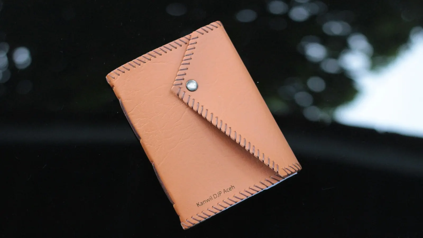 An envelope-style leather journal with Kanwil DJP Aceh branding.