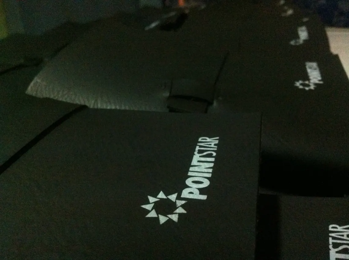 A row of black leather journals with the Pointstar logo debossed