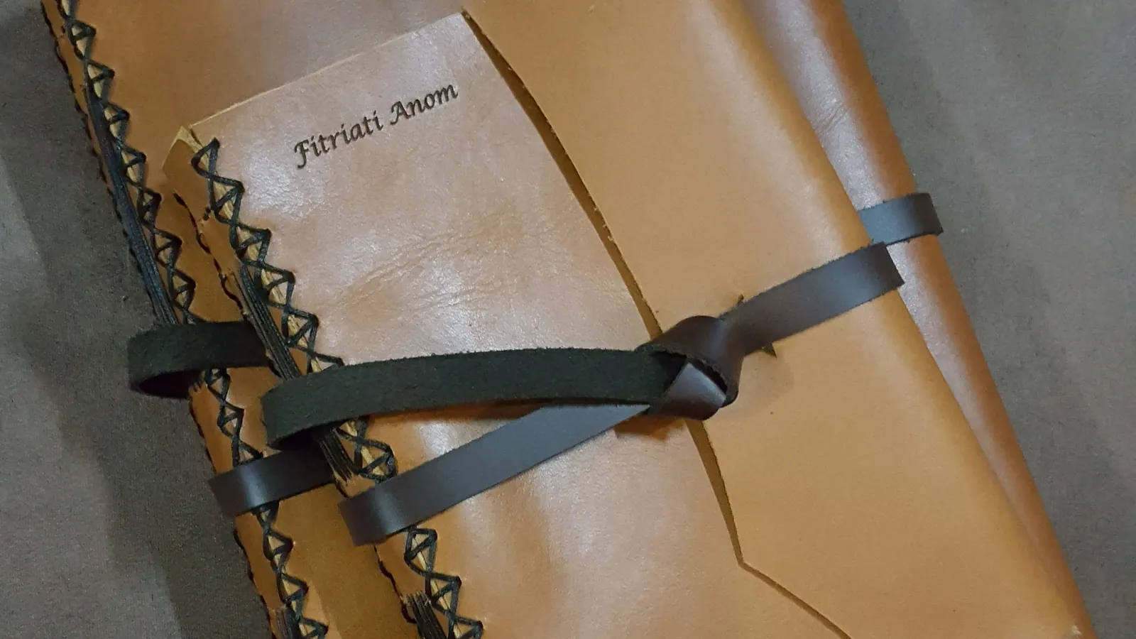 Beberapa jurnal kulit dengan nama penerima masing-masing di-emboss pada sampul.