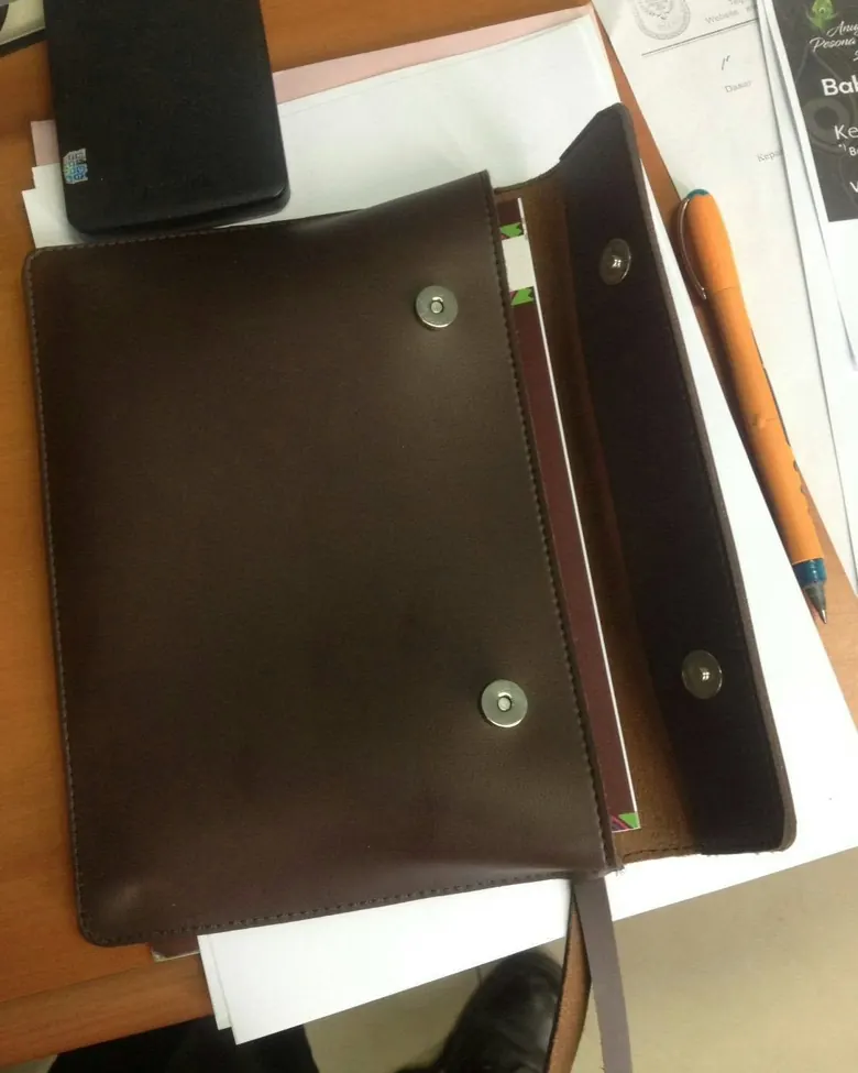 A brown leather journal with a magnetic clasp.