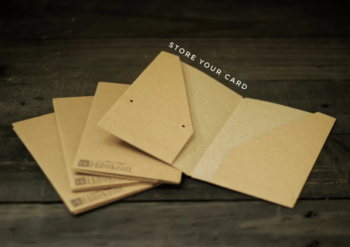Several leather card holders in different colours and finishes, laid out in a row on a wooden table.