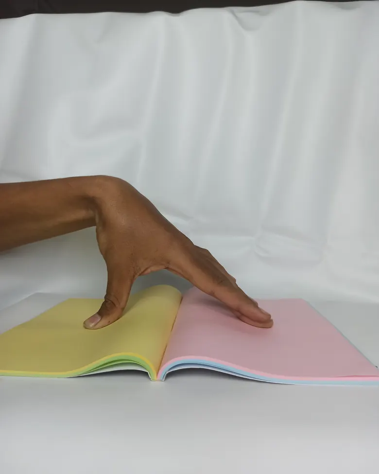 Tangan menekan halaman buku catatan berwarna pastel yang terbuka
