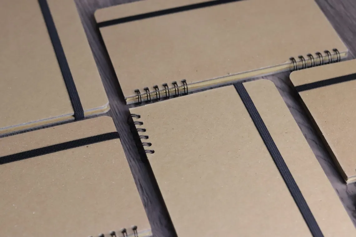 Beberapa notebook spiral dengan tali elastis pengikat, contoh varian isi kit.