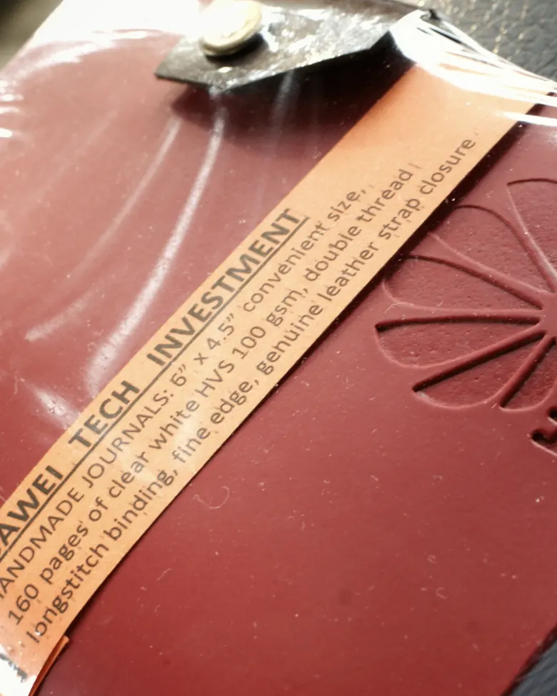 Jurnal kulit merah dengan belly band Huawei Tech Investment