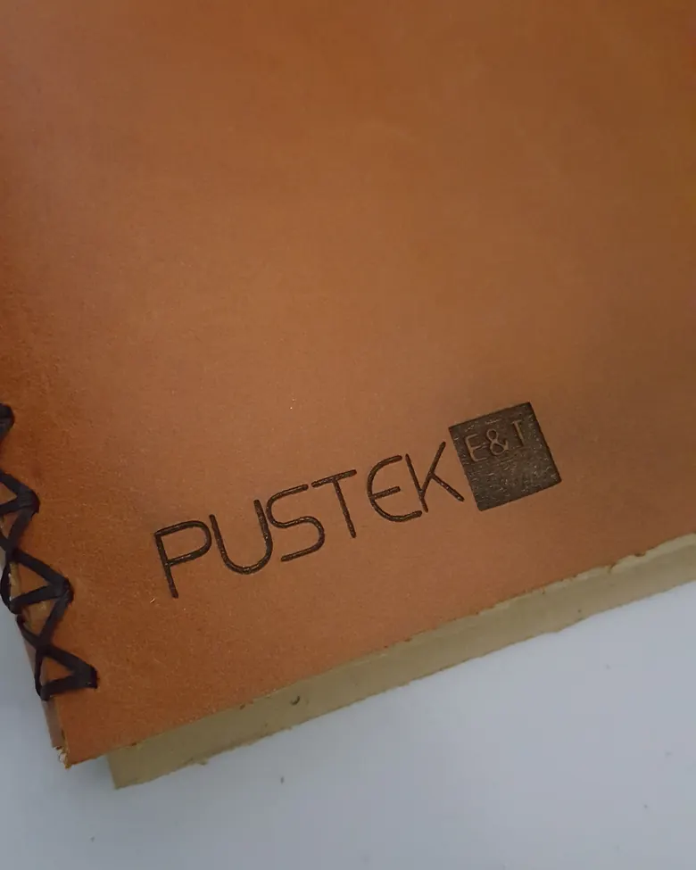Sampul kulit cokelat dengan logo Pustek E&T dideboss