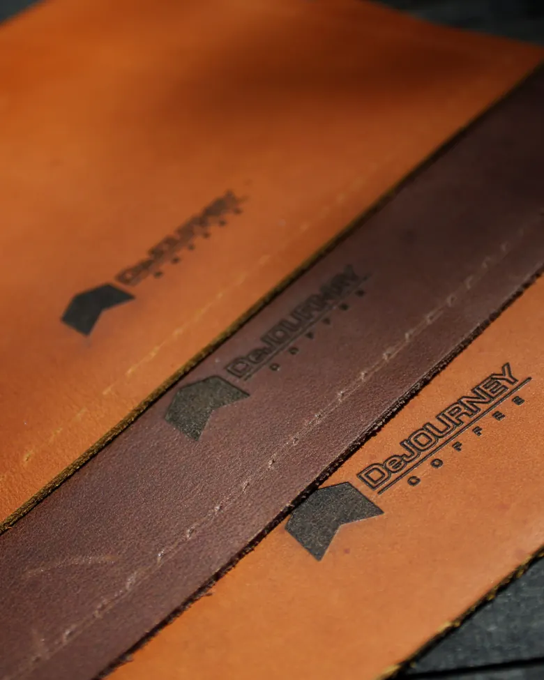 Logo Dejourney Coffee dipahat pada beberapa lembar kulit.