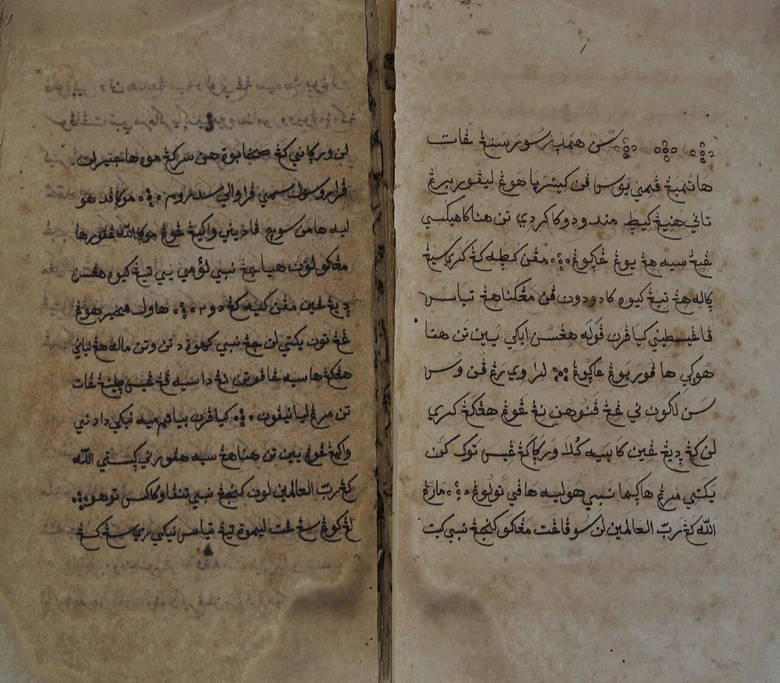 Dua halaman naskah Babad Diponegoro yang menguning, dipenuhi tulisan tangan aksara Pegon (huruf Arab untuk bahasa Jawa) rapat dari kanan ke kiri, dengan noda kecoklatan di beberapa sudut halaman