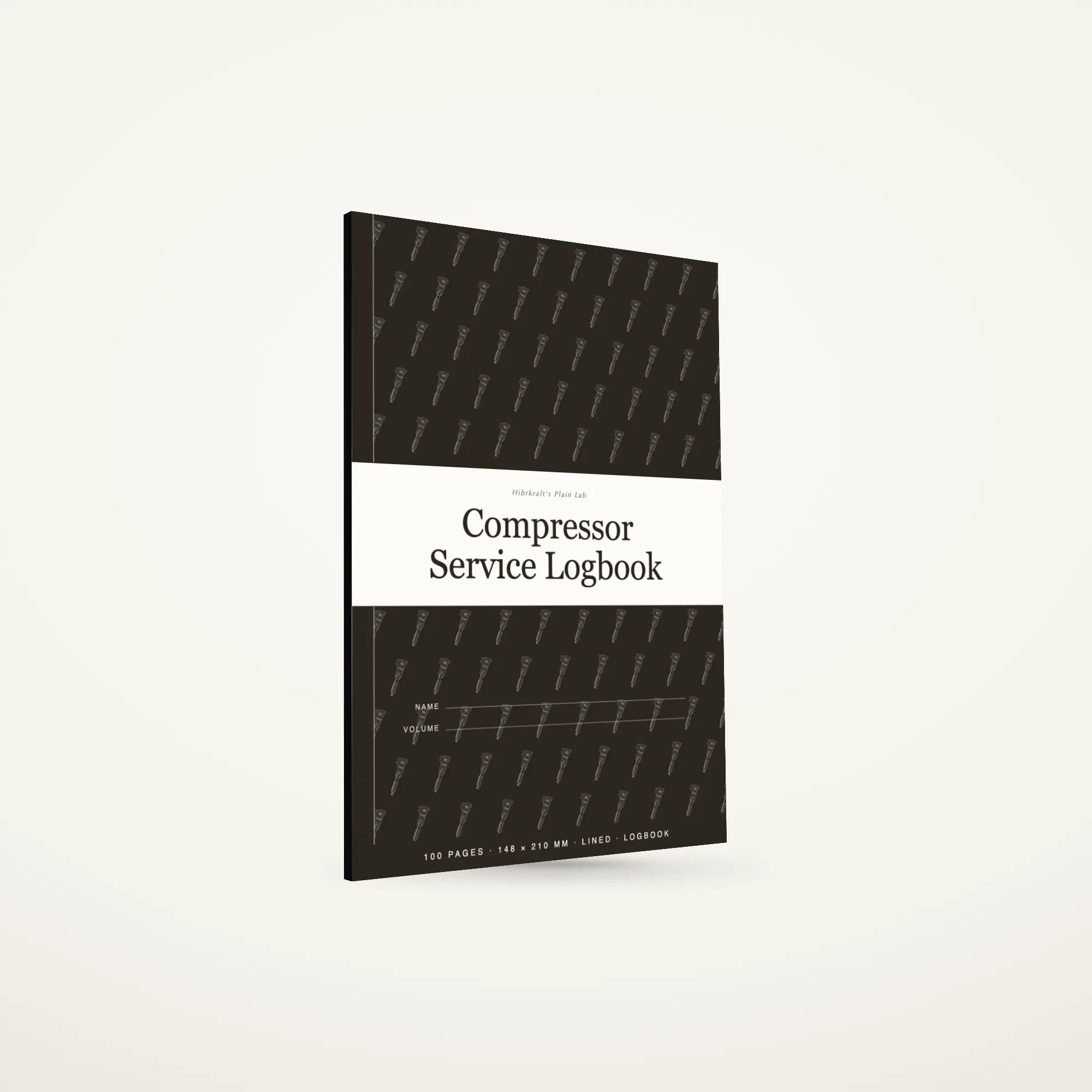O Compressor Service Logbook A5 de pé e fechado sobre uma superfície lisa, capa escura com uma faixa a toda a largura e um motivo de ferramentas, com cerca de seis milímetros de espessura.