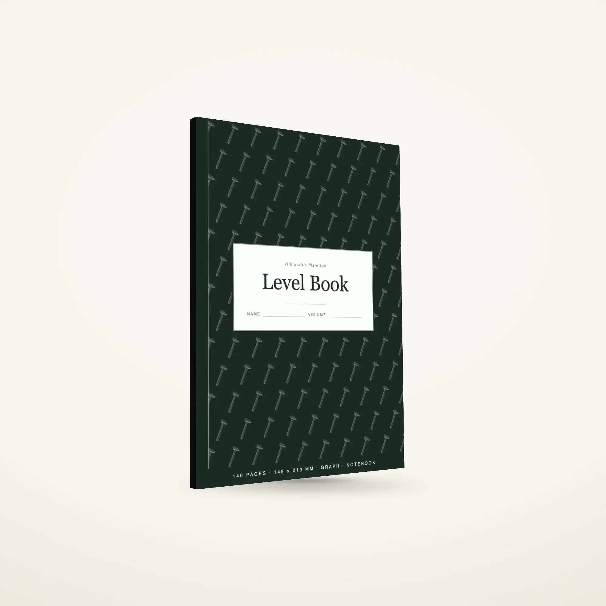 A5 Level Book standing closed, sage cover with a craftsman's tools motif reversed out, about eight millimetres thick.