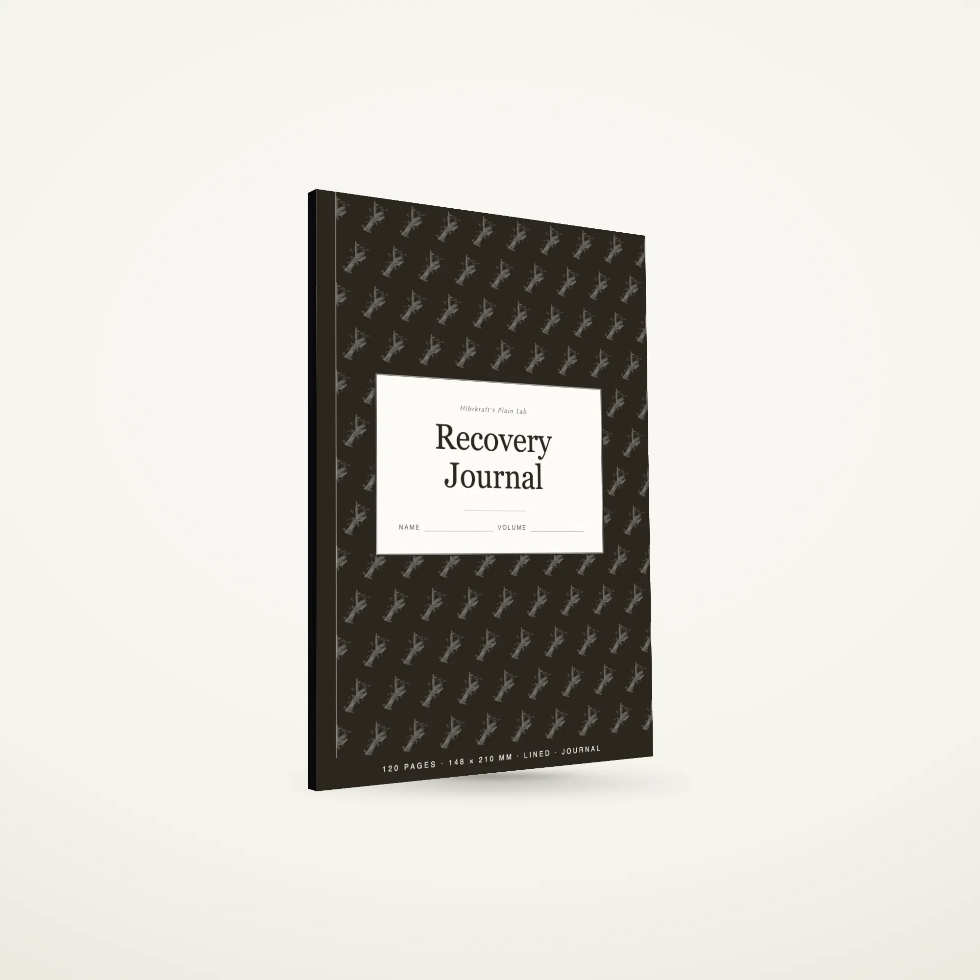 A5 Recovery Journal standing closed on a plain surface, quiet cover with a small motif, about seven millimetres thick.